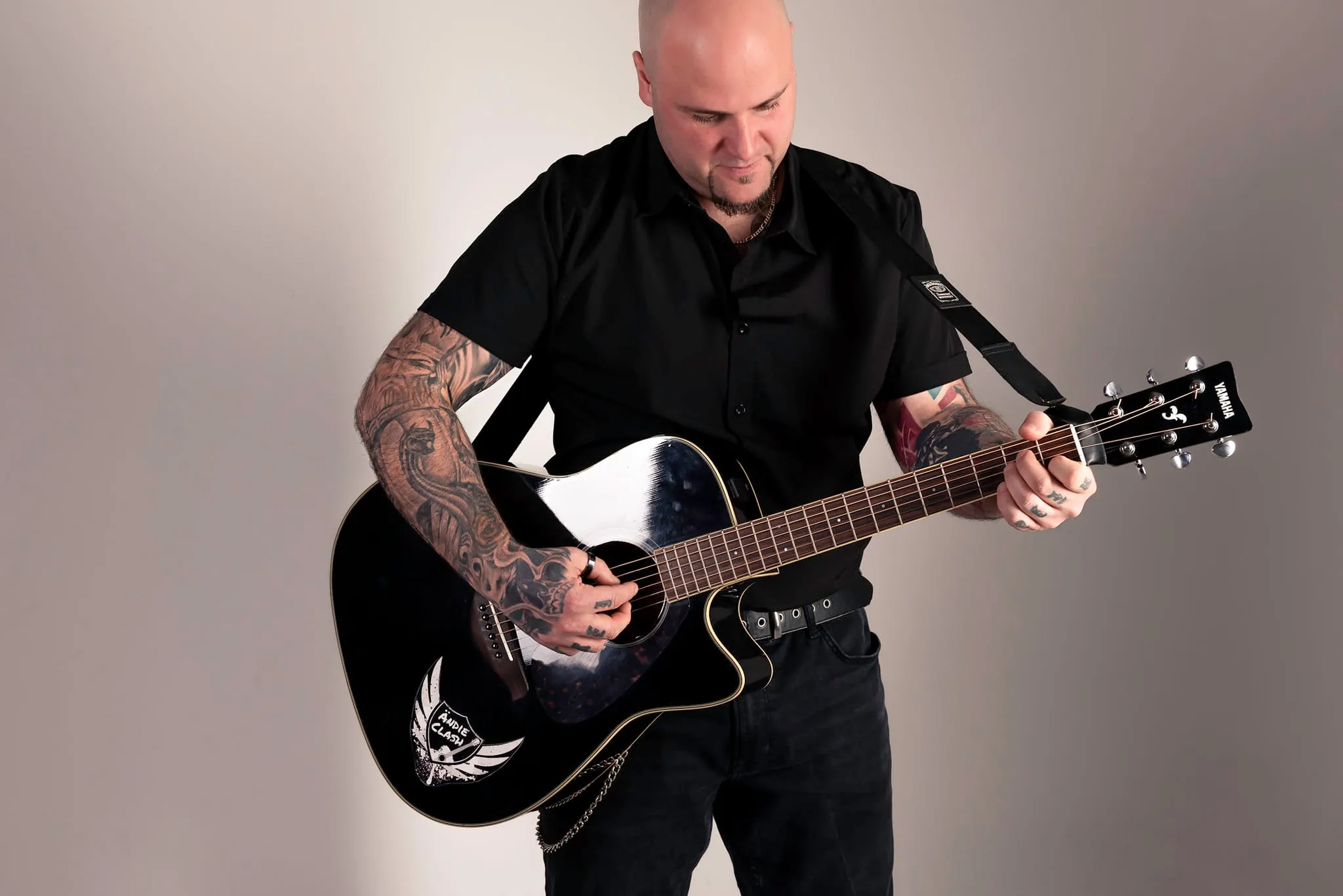 Ändie Clash spielt eine schwarze Akustikgitarre, Portrait vom Cover-Shooting
