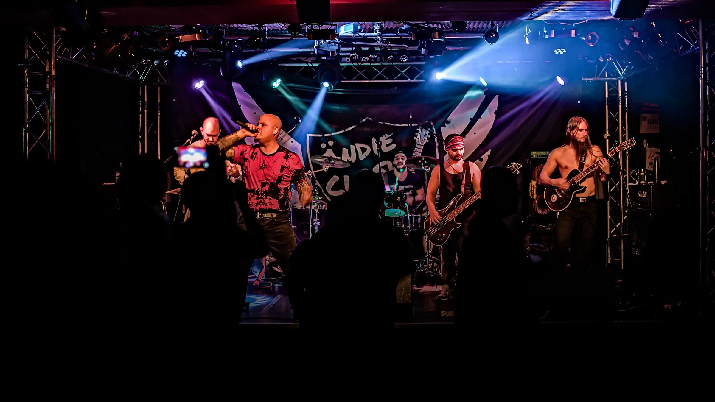 Ändie Clash live mit Band auf der Bühne im Scheinwerferlicht vor Publikum