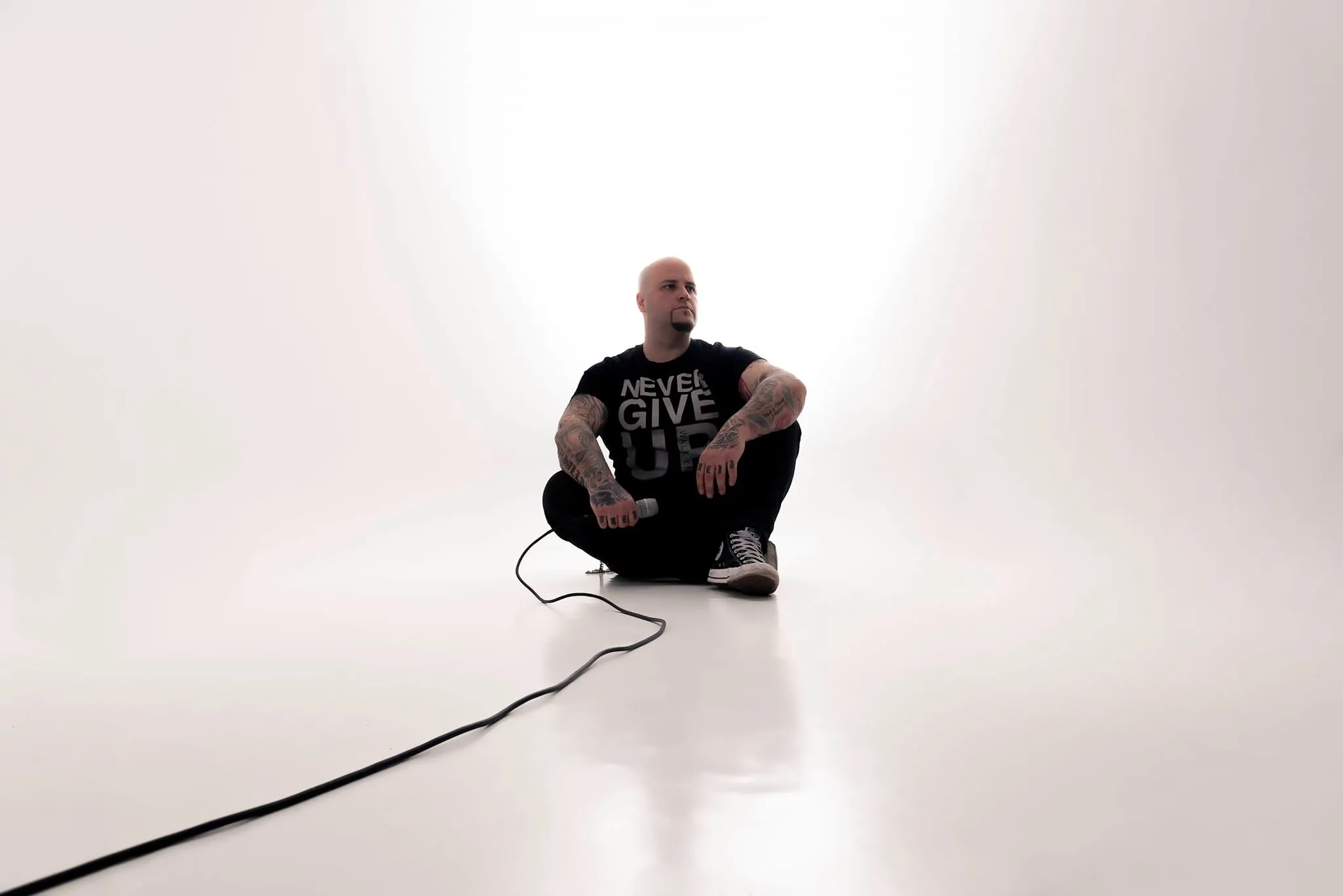 Ändie Clash sitzt im weißen Studio mit Mikrofonkabel, Shooting zum Album Unbesiegbar